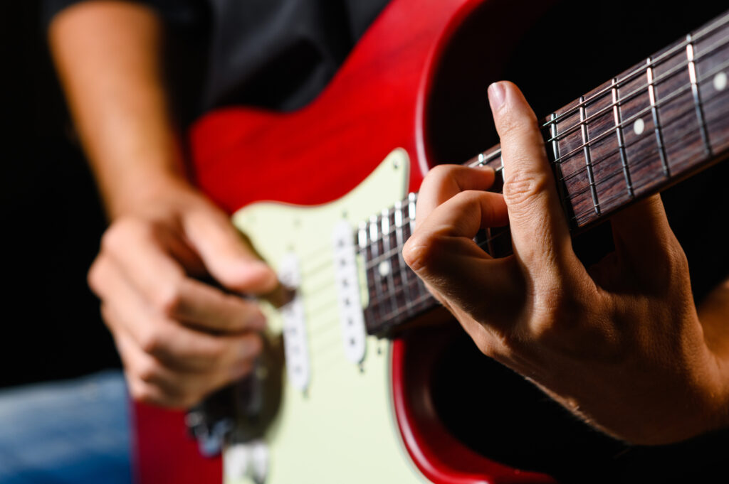 playing the guitar close up. hands of a guitarist on a black background